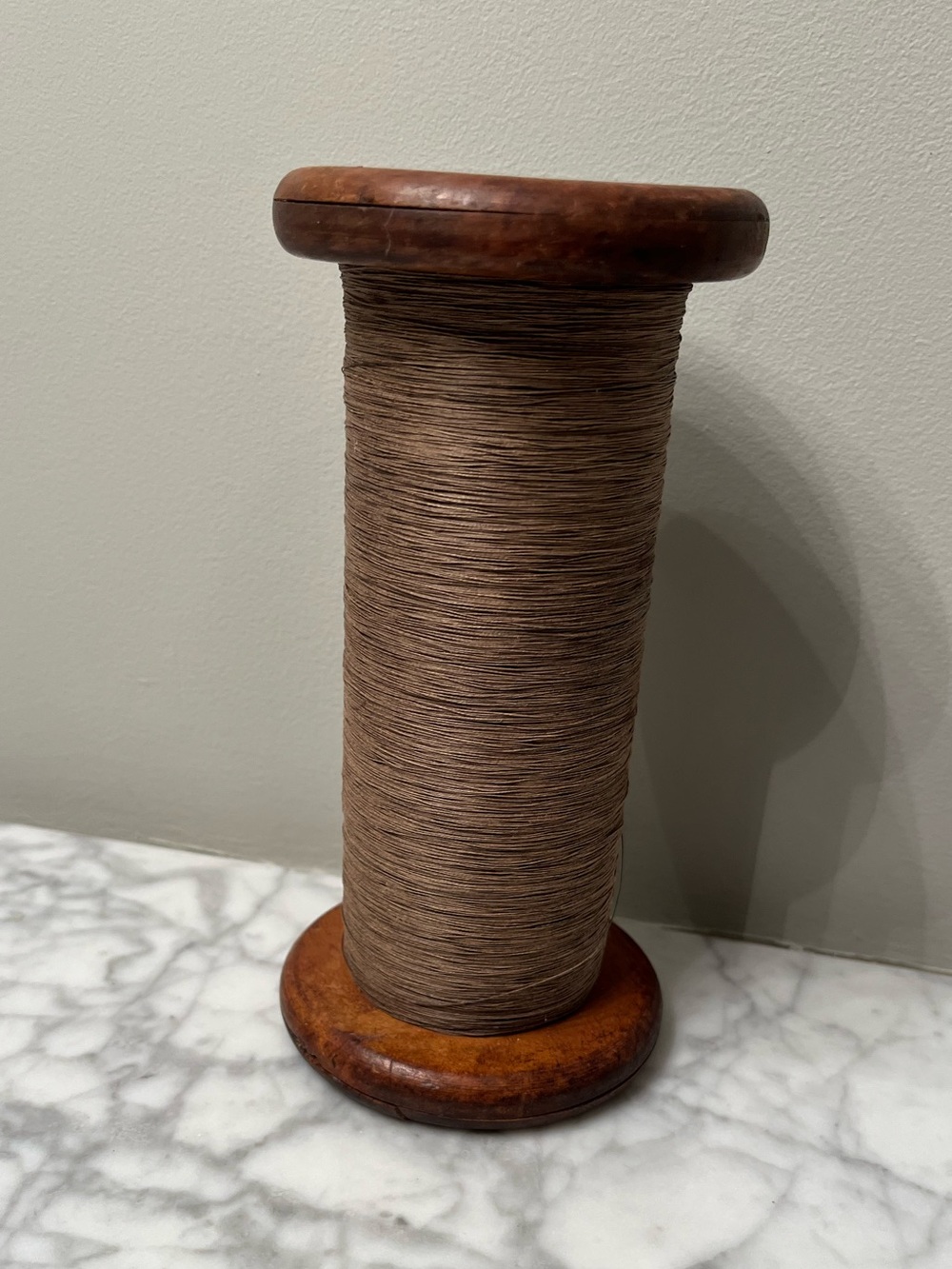 Antique bobbin from one of the many bygone New England mills.  Made of wood.